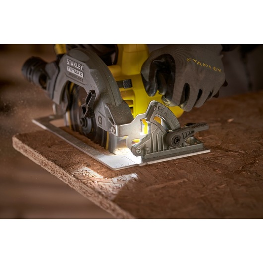 STANLEY SFMCS550M2K circular saw cutting wood, close-up showing blade and integrated LED light.