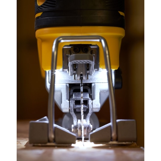 STANLEY SFMCS650B jigsaw close-up front view, blade illuminated, yellow and black body, cutting wood.