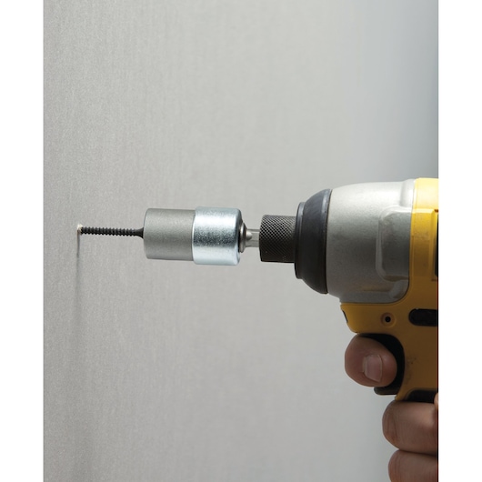 STANLEY STHT0-05926 drywall screw setter attached to drill, side view driving screw into wall.