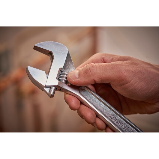 STANLEY STHT13123-0 adjustable wrench held in hand, silver finish, close-up photo.
