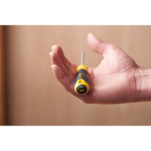 STANLEY STHT16146-0 screwdriver held in hand, yellow and black grip, close-up photo.