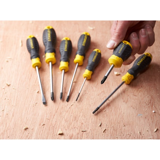 STANLEY STHT16154-0 screwdriver set with black and yellow handles on wood surface, handheld view.