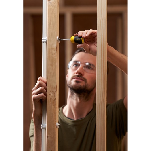 Photo of STANLEY STHT16196-0 screwdriver used on wooden framing, close-up during construction.