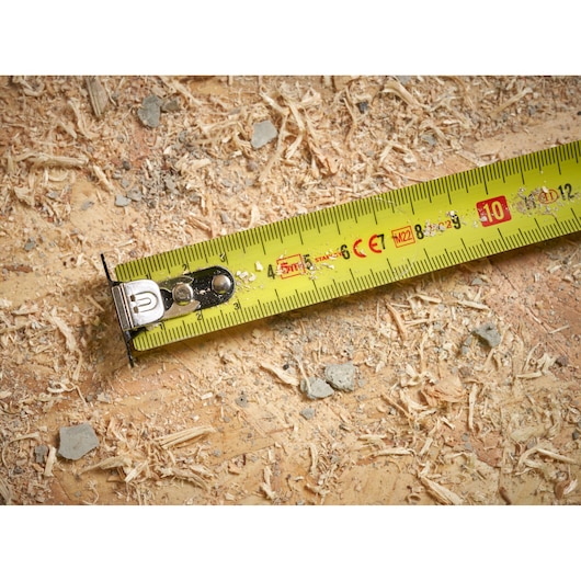STANLEY STHT37231 tape measure on wood surface with sawdust, close-up view.