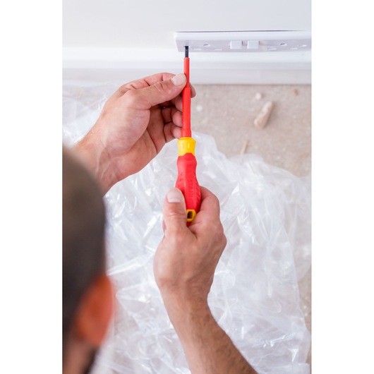 Close-up photo of STANLEY STHT60031-0 insulated screwdriver being used on a wall socket.