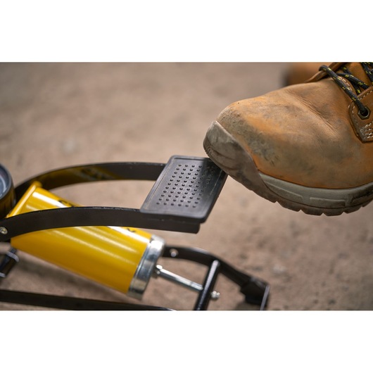 STANLEY STHT80894-1 foot pump with boot pressing pedal, shown close-up outdoors.