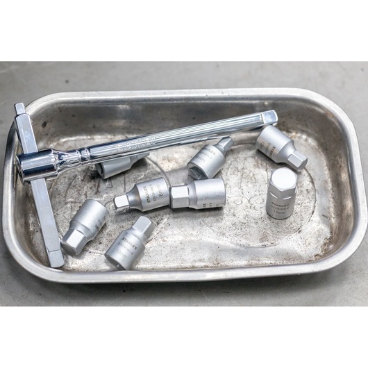 STANLEY STHT81576-0 socket set with ratchet and metric sockets in a metal tray, photographed from above.