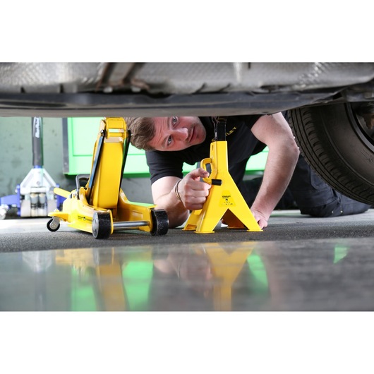 Photo of STANLEY STMT81255-1 yellow car jack and stand under vehicle, automotive tool usage scene.