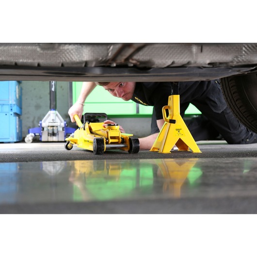 STANLEY STMT81255-1 yellow jack stand and floor jack under car, side angle, automotive tool application.