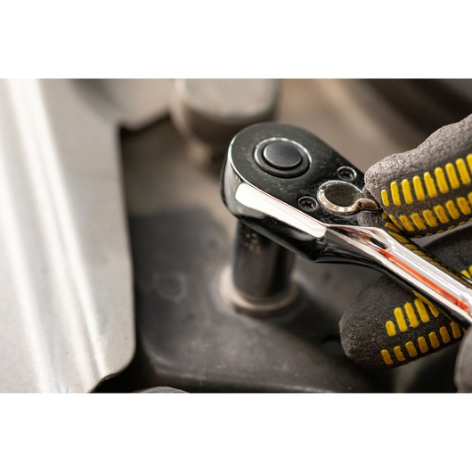 STANLEY STMT82672-0 ratchet wrench in use, close-up, with gloved hand and socket attachment.