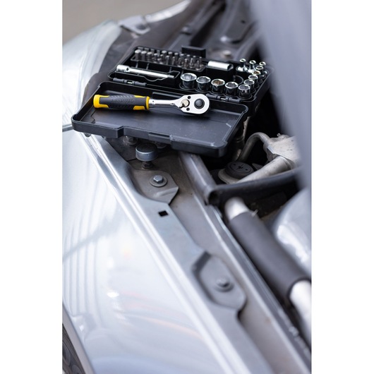 STANLEY STMT82672-0 socket and ratchet set with yellow handle, open case on a car engine bay, angled view.