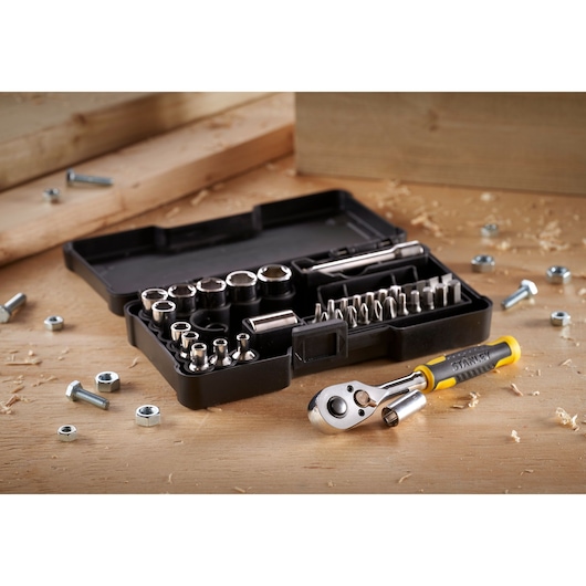 STANLEY STMT82672-0 socket and ratchet set in black case with yellow-handled ratchet on wooden surface.