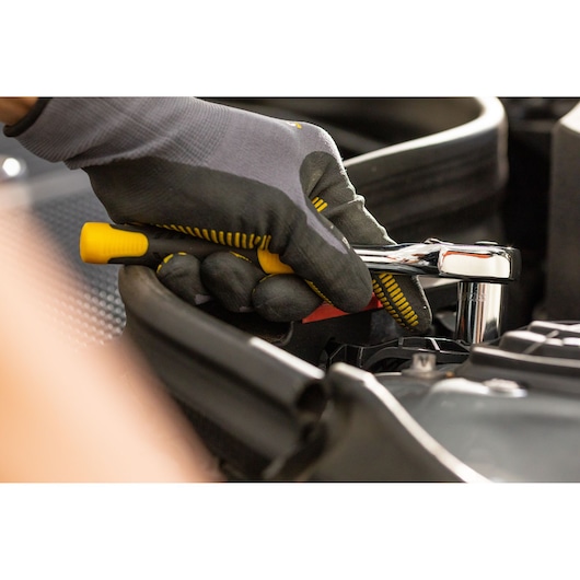STANLEY STMT86305-0 ratchet wrench in use, close-up in automotive setting, yellow and black handle.