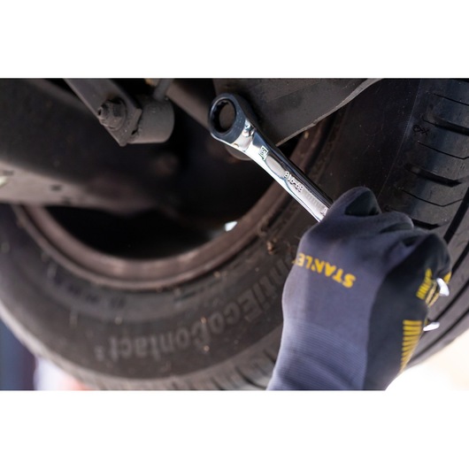 STANLEY STMT89916-0 ratcheting wrench in use on car undercarriage, photography close-up.