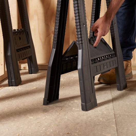 STANLEY STST1-70355 black plastic folding sawhorse, side view, with user opening built-in storage.