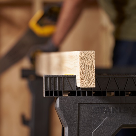 STANLEY STST1-70713 sawhorse close-up with wooden beam in workshop.
