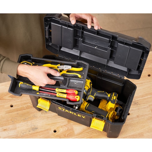 Photo of STANLEY STST1-75520 black toolbox with yellow latches, open to show assorted hand tools and power drill.