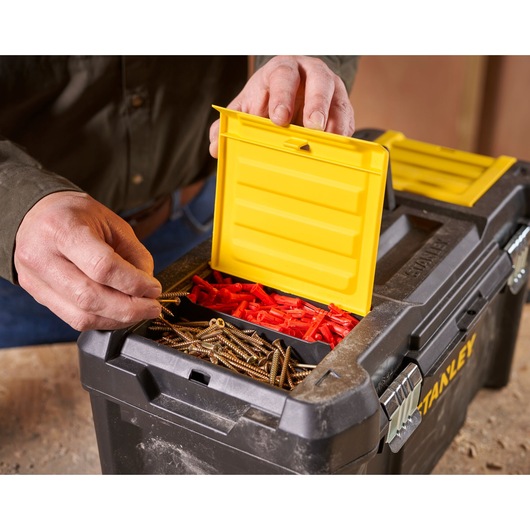 STANLEY STST1-75521 toolbox close-up with yellow lid open, showing screws and wall plugs inside.