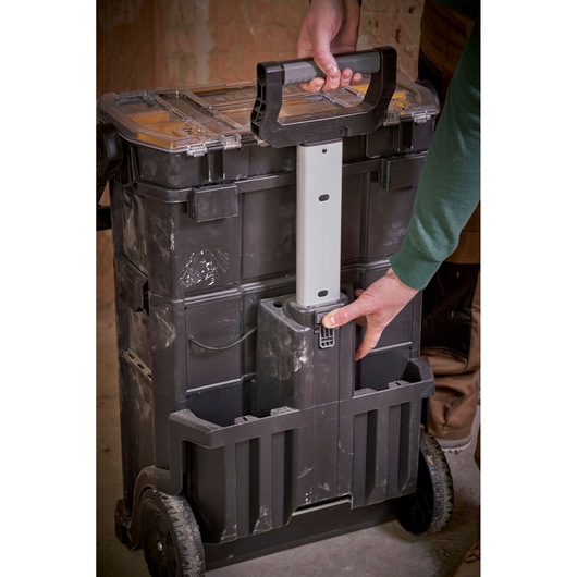 STANLEY STST1-79231 rolling toolbox with extendable handle, photo of person pulling the handle, indoor workshop.