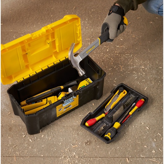 STANLEY STST75785-1 toolbox open on workshop floor with assorted hand tools and yellow removable tray.