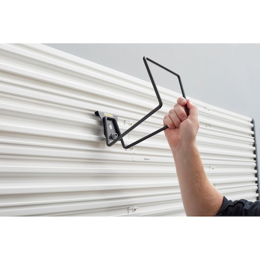 STANLEY STST82604-1 wall-mounted storage hook installation on white panel, side angle.
