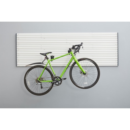 STANLEY STST82615-1 wall storage panel with green road bike mounted on hooks, front view.