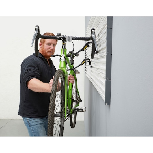 STANLEY STST82615-1 photography of a green bike mounted on wall hooks in a garage setting.