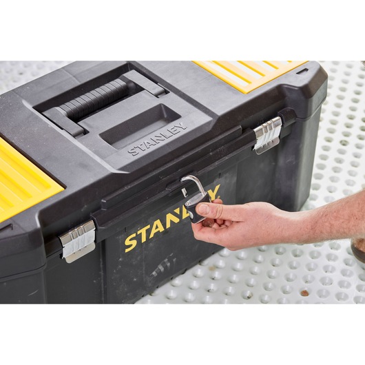 STANLEY STST82976-1 toolbox front angle, black and yellow with padlock being unlocked by hand.
