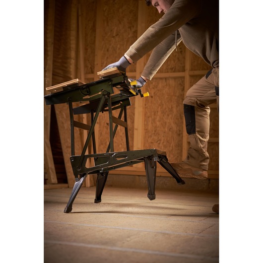 STANLEY STST83800-1 folding workbench in use, black metal frame, photographed in workshop setting.