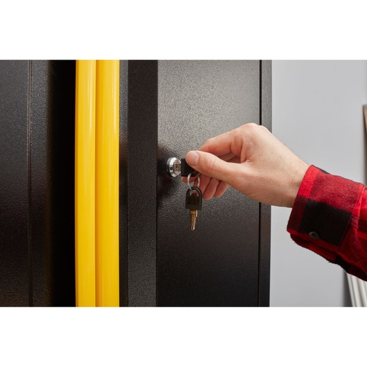 Photo of STANLEY STST97598-1 cabinet with yellow handles being locked with a key, close-up view.