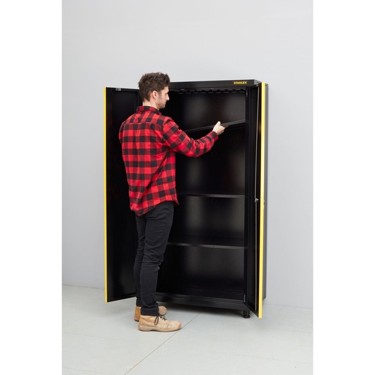 Photo of STANLEY STST97957-1 storage cabinet with open doors, person adjusting top shelf.